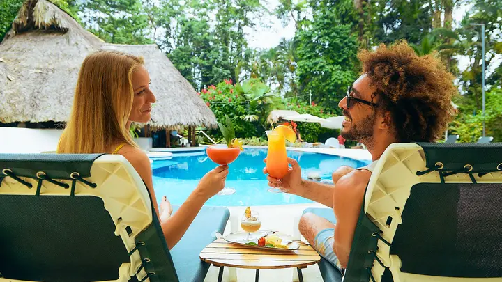 Parents relaxing with drinks by the pool